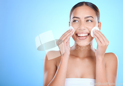 Image of Skincare, face and woman with cotton pads, cosmetics and wellness on blue studio background. Makeup remover, female and Mexican girl with smile, natural beauty and confident for clear and smooth skin