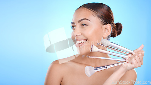 Image of Beauty, woman with makeup and brush in hand with cosmetic tools advertising, foundation and powder against blue background. Model with smile for wellness, skincare and face cosmetics care mockup.