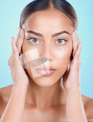 Image of Portrait, face and beauty with a model black woman touching her skin in studio on a blue background. Skincare, cosmetics and antiaging with an attractive young female posing for natural treatment