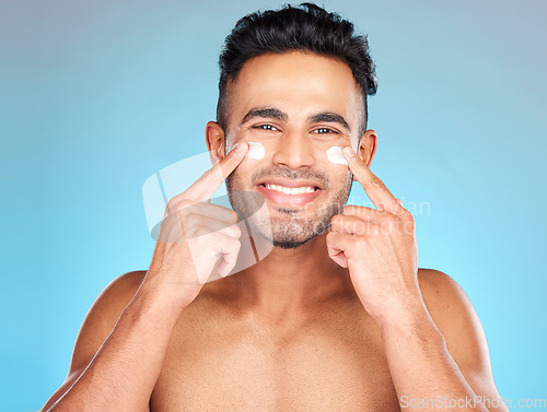 Image of Skincare, eye cream and portrait of man for facial cosmetics, hygiene products or sunscreen in hands. Face, dermatology and male model wellness or spa happiness with smile in blue background studio