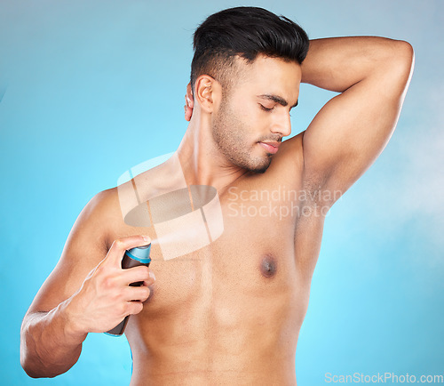 Image of Cleaning, deodorant and man in studio for wellness, hygiene and armpit odor control on blue background mockup. Underarm, perfume and product on guy model in bathroom for sweat, cosmetic and spray