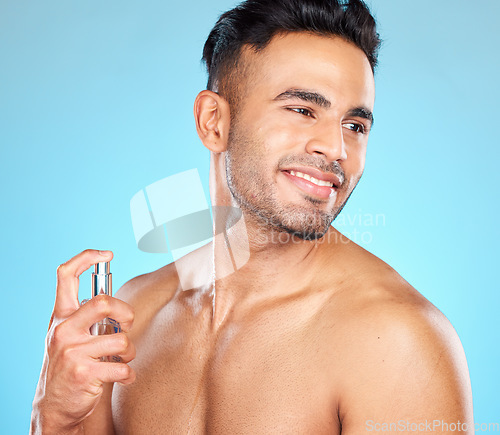 Image of Man, happy and perfume for fragrance, aroma and manly scent on blue studio background. Young male, healthy Latino gentleman and cologne for natural beauty, fresh and smell good for hygiene and relax