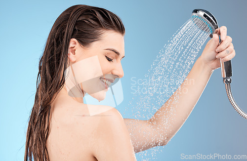 Image of Faucet, shower and woman with water for cleaning, skincare and body care in studio on blue background. Wellness, healthcare and girl washing with water drops for hydration, luxury spa and self care