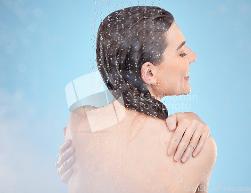 Image of Shower, happy and beauty of wellness woman with body cleaning, self care and grooming routine. Health, hydration and water drops on back of skincare model washing in blue studio with smile.