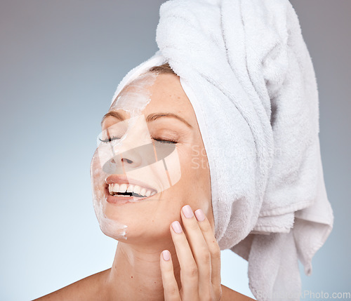 Image of Skincare, cream and woman from the shower, happy cleaning and marketing beauty against a grey studio background. Spa smile, face mask and model with application of sunscreen for body care and health