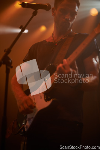Image of Music microphone, rock guitar and man playing electric instrument at metal band festival, dark concert or performance show. Creative stage shadow, star artist and musician singer at night party event