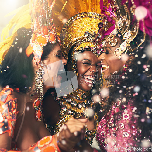 Image of Women, laughing or samba carnival dancers in Brazilian in celebration event, street night party or city performance. Dancing festival, feathers or fashion costume for smile, happy or bonding friends