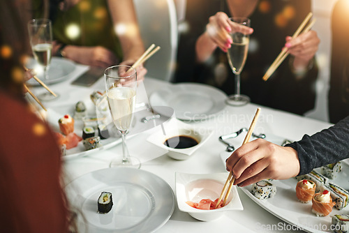 Image of Sushi, friends and eating food together for nutrition, diet and social get together in a restaurant. Meal, asian seafood and alcohol drink with hungry people eat and champagne while gathering