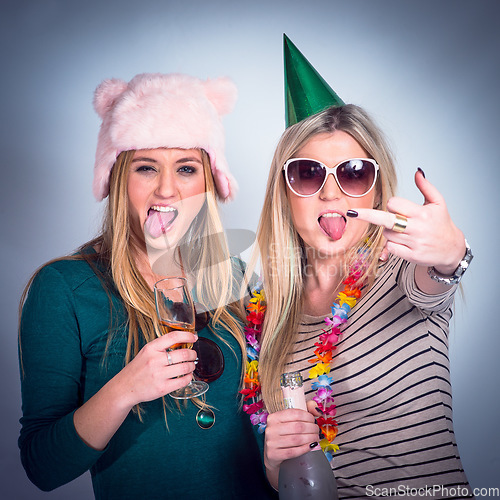Image of Party, drunk friends and drinking alcohol for celebration while crazy, rude and happy on studio background. Women with wine glass and bottle showing middle finger to celebrate birthday drink together