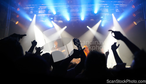 Image of Concert, dance and audience at a band performance, techno festival and event with people on a stage in the dark. Night club, dancing and crowd with freedom, energy and rock at a music festival