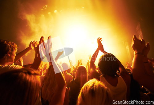 Image of Music, concert and crowd with light, clapping for live performance, rock event and band on stage at night. People, audience and music festival, audio and sound with energy at show with musical artist