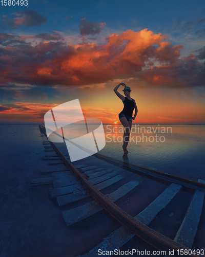 Image of Woman at beauty sunset on salty lake
