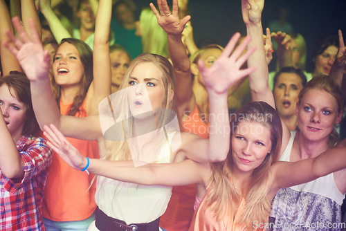 Image of Women, hands up and dancing at music festival, live band performance and techno rave party in nightclub, concert and disco. Friends, crowd and audience on dance floor in show, freedom or energy event