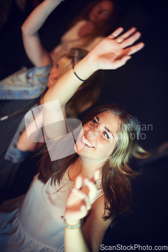 Image of Women, arms up or dancing in night party, music festival or social gathering event to live music, band performance or techno friends rave. Smile, happy or woman dancer on crowd dance floor and energy