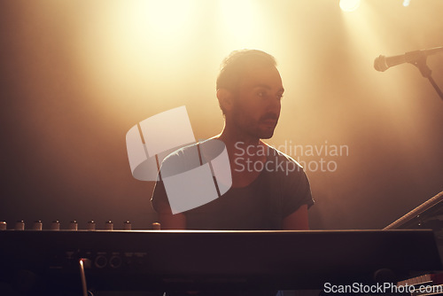 Image of Musician, keyboard and concert for singing on dark stage, music festival or talent show for entertainment. Professional music artist, focus or dream gig at event, performance or playing by microphone