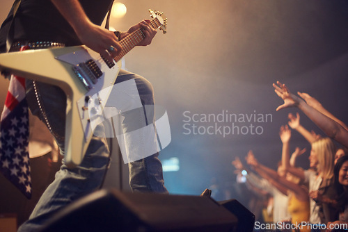 Image of Concert musician, guitar and rock on stage for crowd, party or festival gig in night with american flag. Professional artist, band and music festival for event for talent, music solo and performance