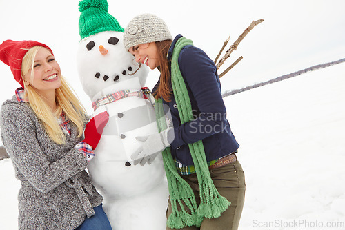Image of Women, snow and building a snowman in winter during Christmas while having fun and bonding. Friendship, winter and xmas or festive season with ladies creating a frozen snow man in cold weather