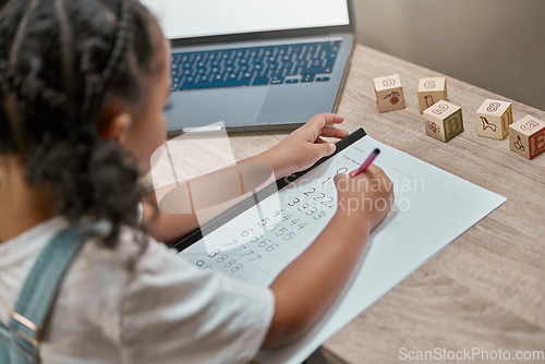 Image of Girl learning, writing and paper for maths, study and cognitive development in home school with laptop. Young african student, female studying numbers and focus with pen, tech and thinking in house