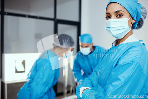 Image of Medical, surgeon or doctor in scrubs and face mask in hospital with staff working during covid virus crisis for health and wellness with safety. Portrait of a woman with arms crossed for healthcare
