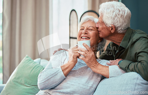 Image of Kiss, coffee and senior couple laughing, talking and smile during retirement in the living room of their house. Relax, love and elderly man and woman with affection, tea drink and comic conversation
