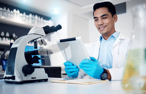 Image of Science, tablet and microscope with a man at work in a laboratory for research or innovation. Doctor, medicine and healthcare with a male engineer working in a lab for future medical development