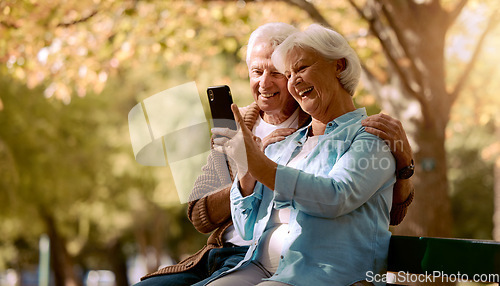 Image of Senior couple, selfie and smile in park, happy and trees by blurred background for social media. Elderly man, old woman and smartphone on park bench for happiness photo, love or video call in Quebec