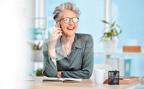 Image of Phone call, communication and laughing with a senior woman sitting in her office, working alone and networking. Contact, mobile and business with a mature female employee joking while speaking