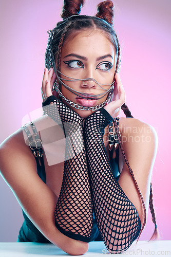 Image of Model, bdsm and sexy clothes with leather, grunge fashion or edgy makeup, jewelry and erotic aesthetic on pink background. Face of girl with chain mask, creative wear and rock cosmetics in studio