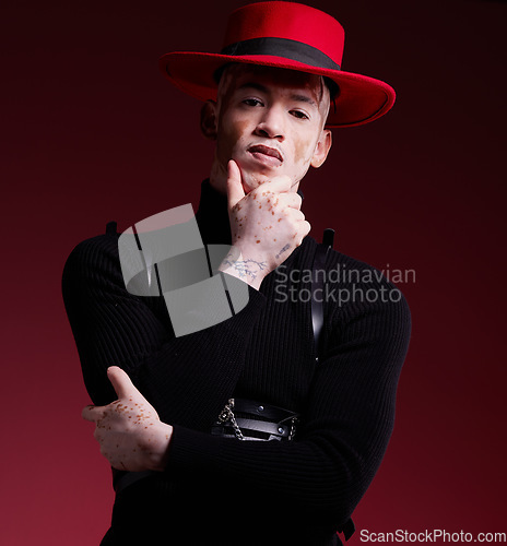 Image of Man, fashion style or vitiligo skin on red background studio in empowerment, self love or attitude. Portrait, aesthetic or model with cool, stylish or edgy clothes or South Africa facial pigmentation