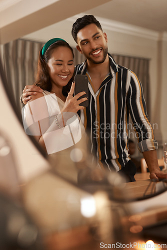 Image of Dinner party, celebration and couple with selfie on a phone in mirror enjoy holiday, festival and Christmas party. Social event, restaurant and young happy man and woman take picture with smartphone