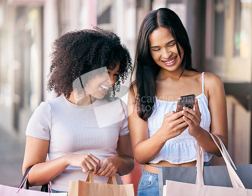 Image of Shopping, phone and women or friends sales, discount or promo code check on a website, social media and retail store for e commerce. City, urban street and young customer people smartphone with bag