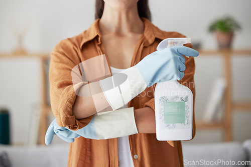 Image of Woman, spring cleaning and spray bottle with arms crossed for housekeeping, sanitation or disinfection of dirt, bacteria and dust in home. Closeup maid, chemical cleaner product and house maintenance