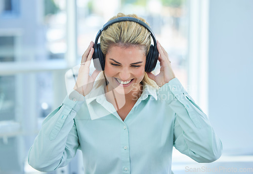 Image of Business woman, headphone and listening to music, podcast and streaming on break in the office with happy smile. Female employee listen to audio, happiness and smiling while enjoy time off from job