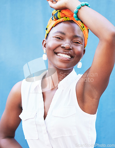 Image of Fashion, happy glow and face of a black woman advertising jewelry, clothes and makeup against a blue background in studio. Color, marketing cosmetics and portrait of an African girl with happiness