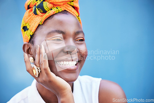 Image of Makeup, black woman and smile with head wrap, eye lash color or confident on blue studio background. Jamaican female, girl and lady with traditional headscarf, stylish or cosmetics for natural beauty