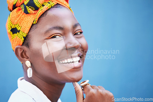 Image of Portrait, black woman and smile with head wrap, natural beauty or confidence for cosmetics on blue studio background. Jamaican female, girl or young lady with traditional headscarf, stylish or makeup