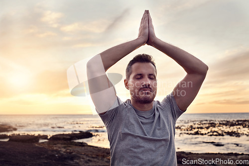 Image of Sunrise yoga, peace and man at the beach for mind wellness, spiritual freedom and relax exercise by the ocean in Bali. Zen meditation, soul training and person at the sea for calm in the morning