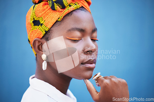 Image of Cosmetics, skincare and black woman with head wrap, natural beauty and wellness against a blue studio background. Jamaican female, girl and makeup for eyelash color, traditional headscarf and mockup.