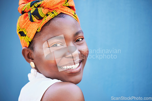 Image of Black woman, face portrait and happy smile with makeup, beauty and fashion scarf on her head with blue wall background. Young female with natural cosmetics, happiness or smiling outdoor with mockup