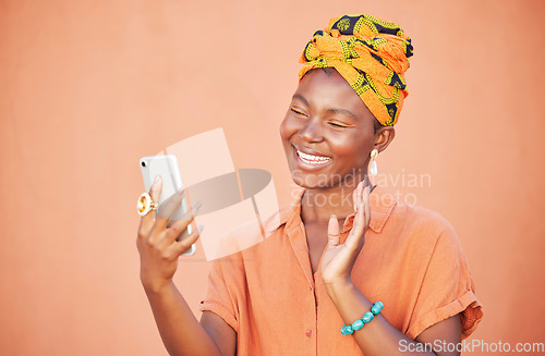 Image of Black woman, phone and video call, wave and communication outdoor against peach wall outdoor. Girl, fashion and virtual conversation, video conference and happy smile or talking with smartphone