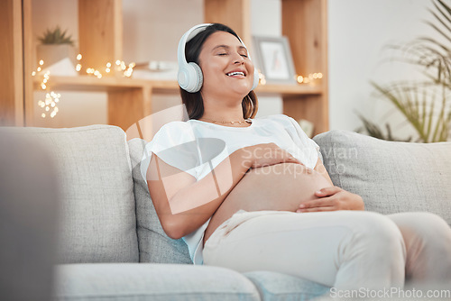 Image of Pregnant woman, relax and headphones for listening to music on sofa for healthy zen, calm and peace for wellness or soothing at home. Happy female with pregnancy tummy on living room couch to rest