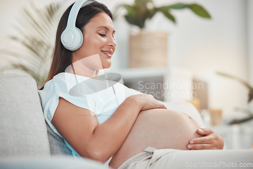 Image of Pregnant woman, music and holding belly or bump while relaxing and bonding with her baby at home. Babies, mother touching stomach and listen to audio on headset for bond in family home