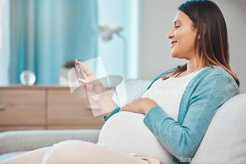 Image of Pregnant, ultrasound and woman sitting on a sofa in the living room of her home with a baby bump or belly. Mother, pregnancy and photograph with a female parent in her house to relax alone