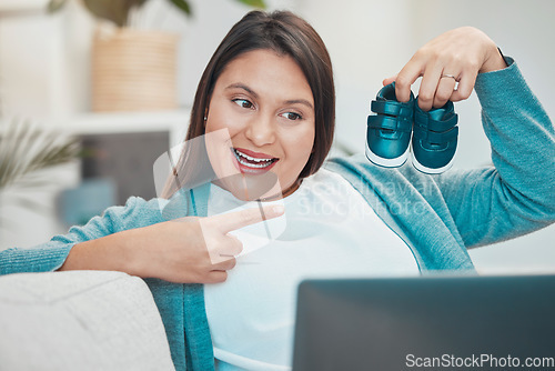 Image of Video call, laptop and baby shoes with a mother making an online announcement about pregnancy. Pregnant, footwear and video conference on the internet with a woman excited about being a parent