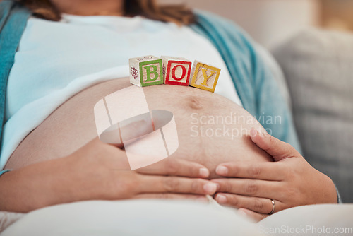 Image of Pregnancy, blocks and woman hands on stomach or relax on sofa in living room for calm parenthood, childcare and mother support. Pregnant woman, wellness and stomach or baby growth with mom on couch