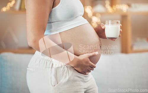 Image of Woman, pregnant stomach and glass of milk for nutrition, wellness or healthy diet of future baby. Pregnancy, abdomen and lady drinking dairy for body care, maternity and vitamins, protein and calcium
