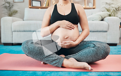 Image of Woman, pregnant and holding stomach, yoga and pilates exercise on the floor, living room and home. Mother, pregnancy or fitness training, wellness workout or calm meditation for healthy body in house