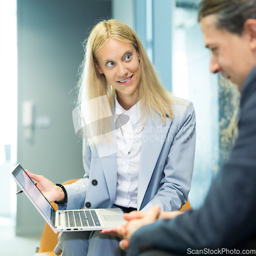 Image of Business meeting. Client consulting. Confident business woman, real estate agent, financial advisor explaining details of project or financial product to client in office.