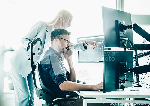 Image of Stock broker business team trading online watching charts and data analyses on multiple computer screens in modern corporate work station office.