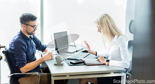 Image of Business meeting. Client consulting. Confident business woman, real estate agent, financial advisor explaining details of project or financial product to client in office.